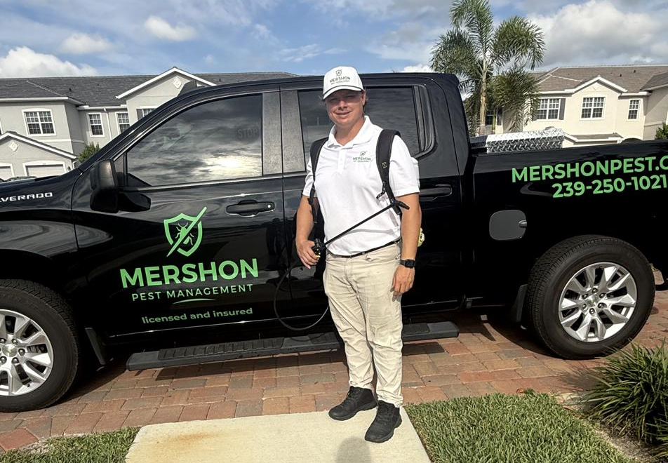 RJ Mershon, owner of Mershon Pest Management, standing with his truck in Naples